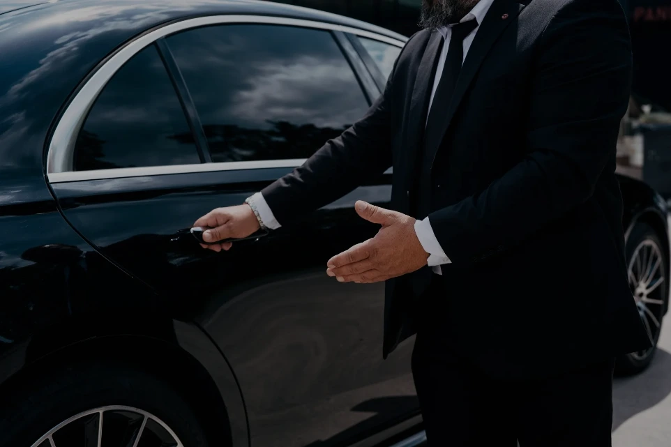 Chauffeur öffnet die Tür einer Mercedes S-Klasse für einen Fahrgast
